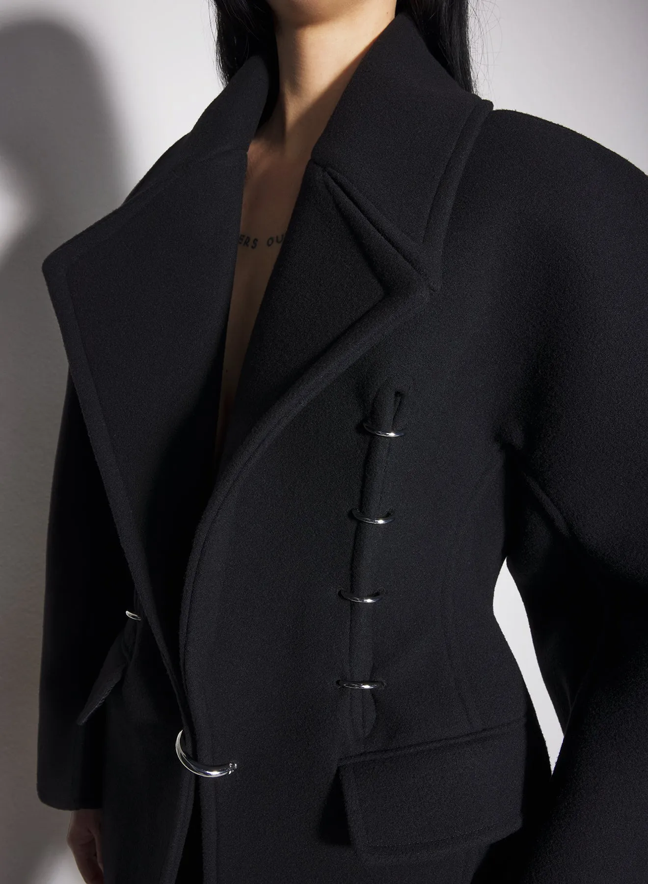 black pierced wool coat